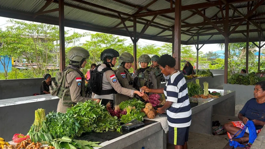 Police officers buying vegetables from a vendor at a covered market