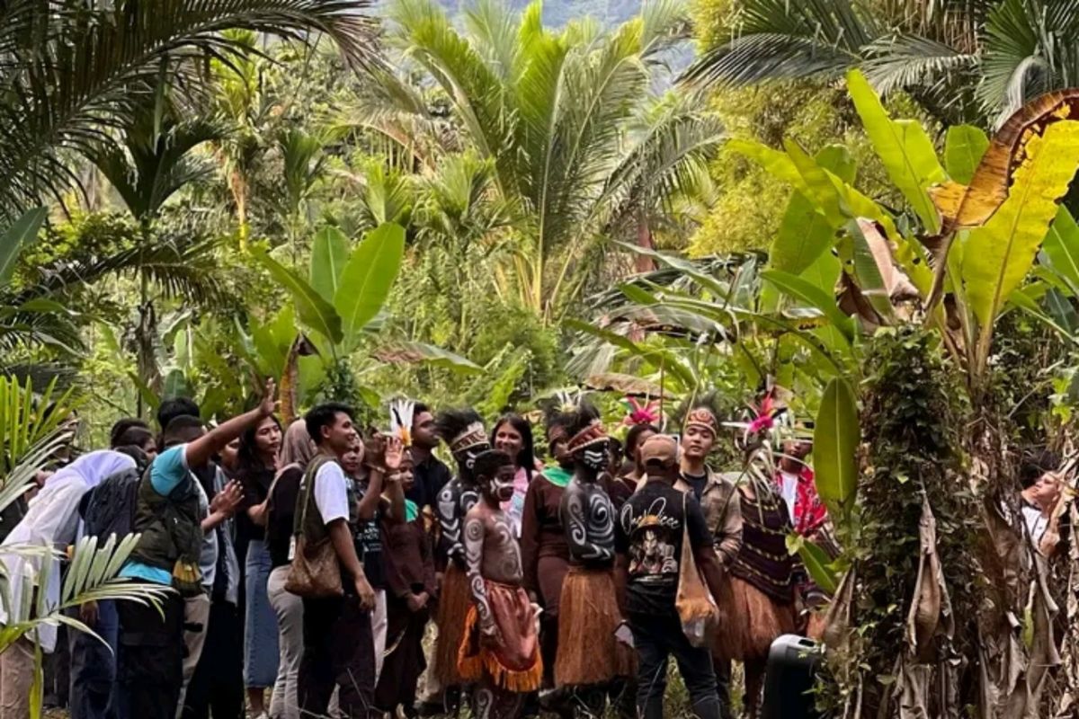 Residents in traditional dress gathered under palm trees.
