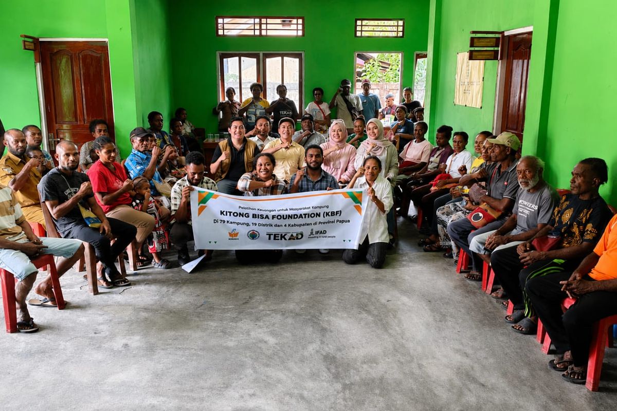 Training participants seated in a hall behind a banner.