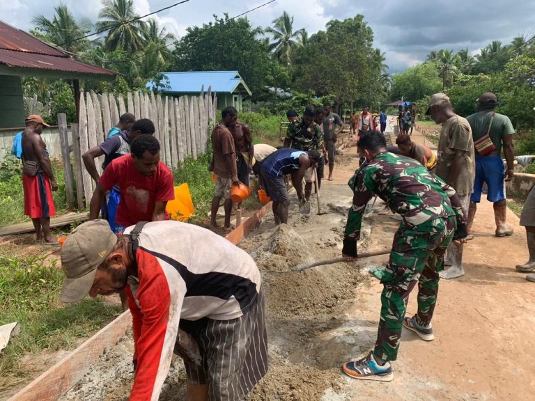 Soldiers and residents working together on a village road.