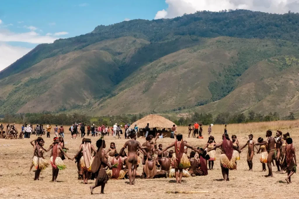 Traditional dance performance on an open field in a highland valley.