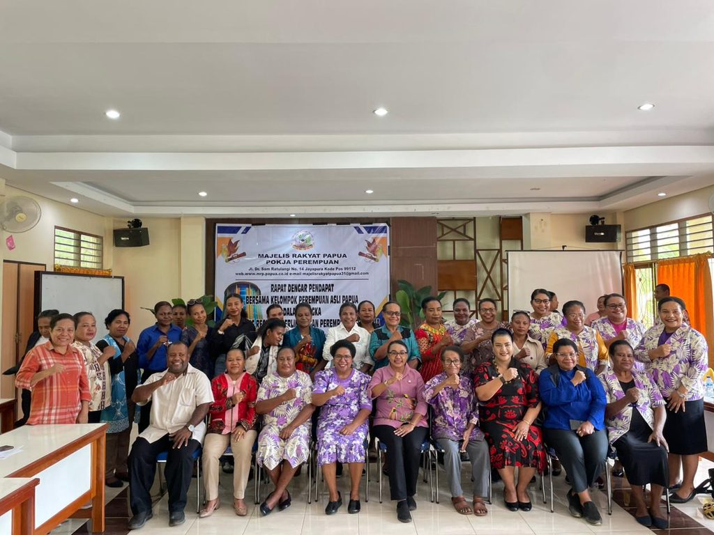 Women posing for a group photo at a Papuan People’s Assembly women’s working group meeting