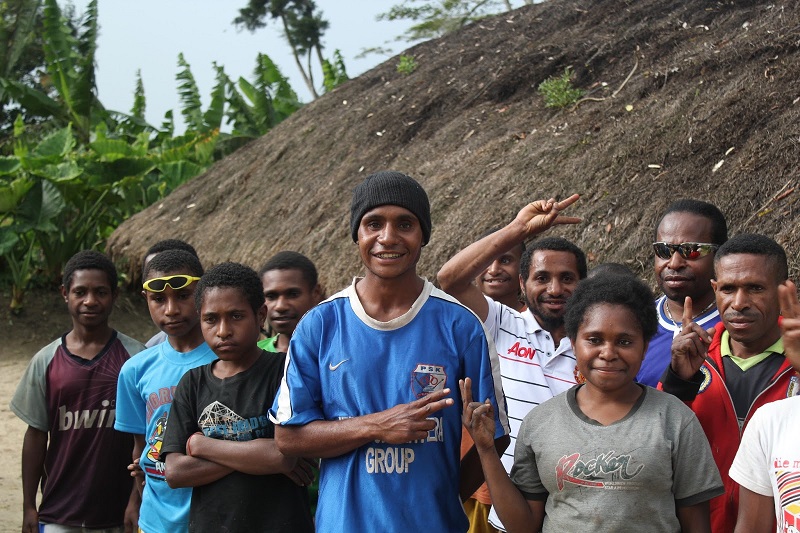 A group of young people smiling beside a hillside garden
