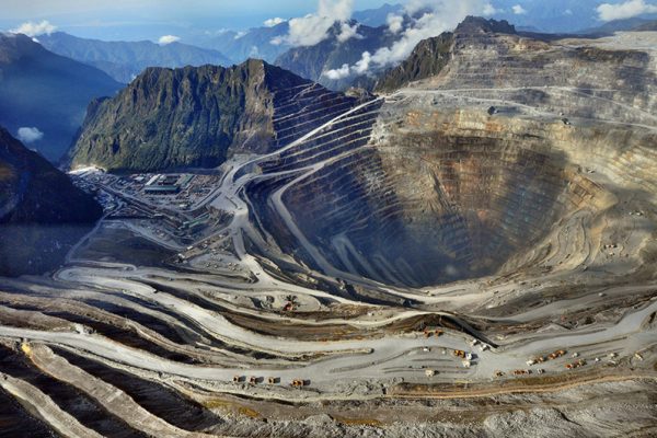 Aerial view of the terraced open pit of the Grasberg copper and gold mine surrounded by mountains in Mimika, Papua