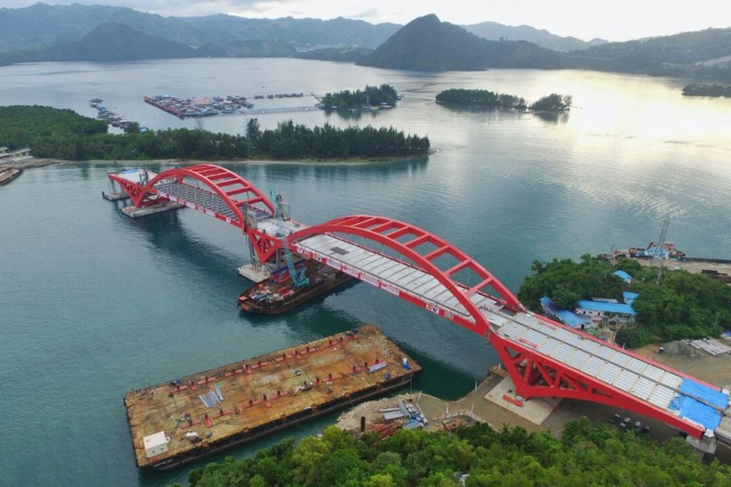 Aerial view of the red-arched Youtefa Bridge over Youtefa Bay in Jayapura