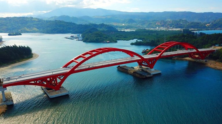 Red arch bridge over a bay near Jayapura.